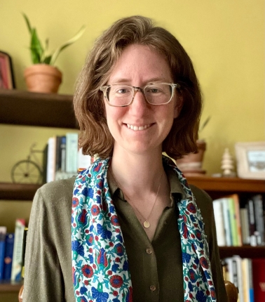 Headshot of HPM Assistant Scientist Michelle Duren wearing a light blue scarf with a pattern of various dark blue and purple shapes over a navy green blouse