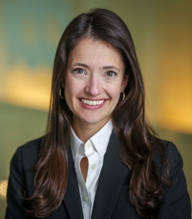 A headshot of a woman with long, dark brown hair