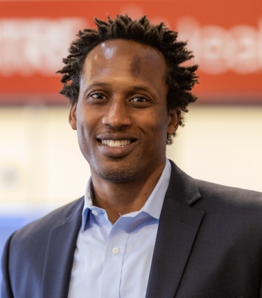 A headshot of a man smiling