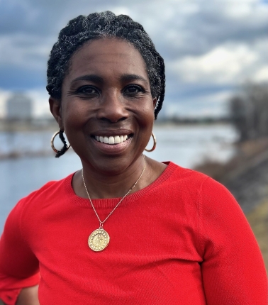 A headshot of Kaytura Felix, a dark skin toned woman wearing a red blouse