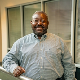 Darrick White smiles for a professional photo in the 2024 E. Monument Street building.