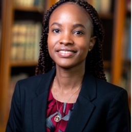 Kimberly Mihayo Woman in front of bookcase