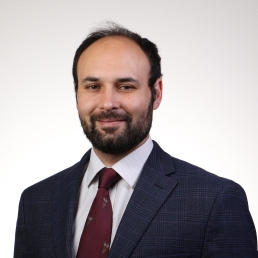 Scott Pilla smiles for a professional headshot in front of a white background.