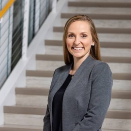 A headshot of Kali Thomas, a woman with a light skin tone and shoulder length blonde hair