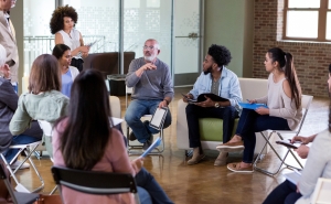 group of adults sitting in a circle talking