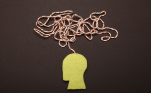 A yellow silhouette of a human head with a jumble of red and white string coming out of the stop