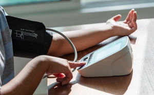 Image of person checking their blood pressure with device