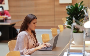 Student working at a laptop in the Bloomberg School reading room 