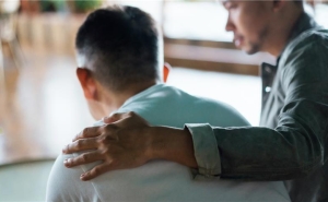 man comforts another man