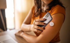 woman with iPhone and glucose monitor