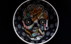 View of cigarette butts on an ashtray with an image of a sugar skull, in Mexico City. 