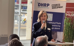 Photo of Professor Meg Davis holding a microphone and speaking before an audience for a sidebar event at the World Health Assembly.