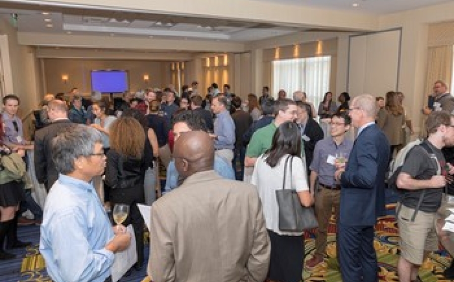Current and former BMB department members fill a room, chatting in small groups
