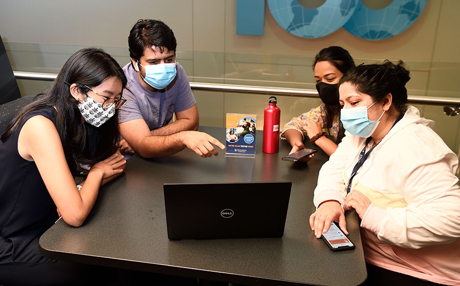 Gathering of students around a computer.