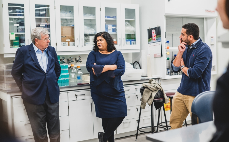 Adler, Weeraratna, and Rebecca discuss Rebecca's skin cancer research while standing in Rebecca's lab. Professors Rebecca and Weeraratna chat with Bob Adler in a lab