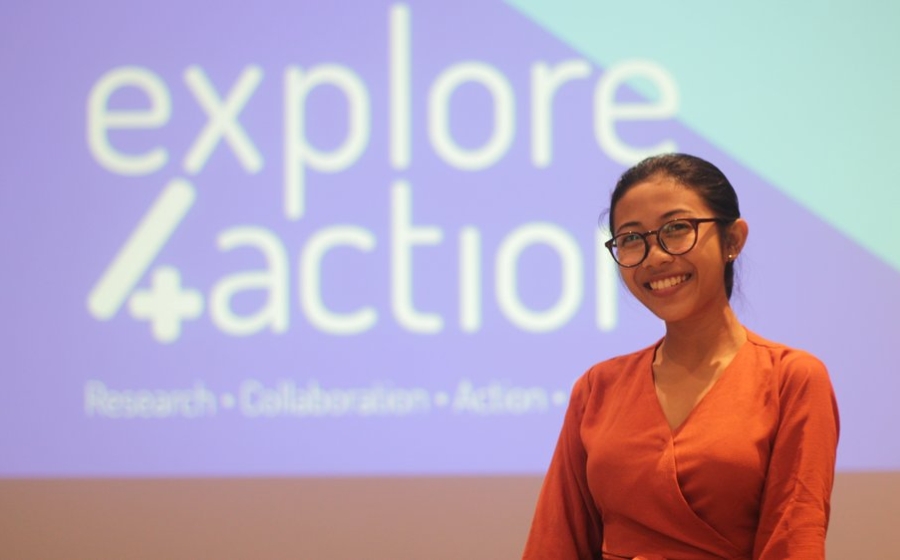 young adult woman standing in front of a large screen after finishing a presentation Explore 4 Action
