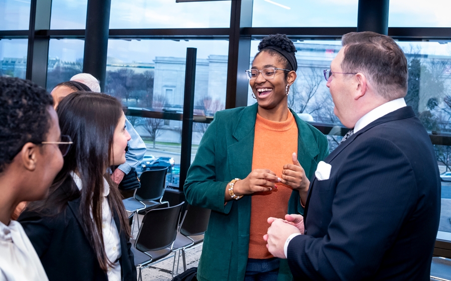 Members of event crowd socialize.