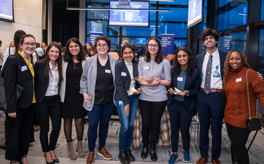 A group of audience members stand and smile for a picture.
