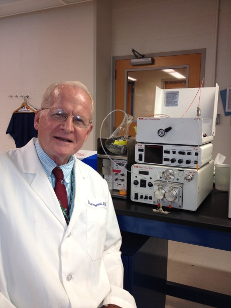 man in lab coat next to scientific machine