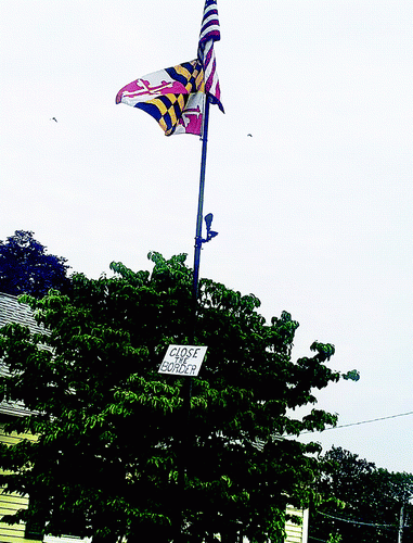 American Flag on a flagpole with a sign below it that reads "Close the Border."