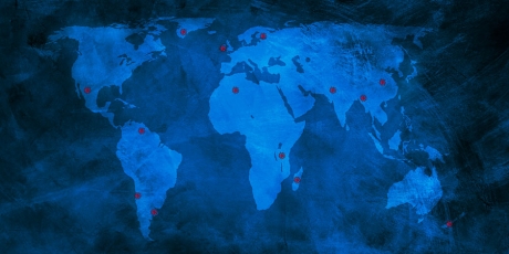 Blue map of the world with red spots indicating countries covered in GHN's Covid country series so far