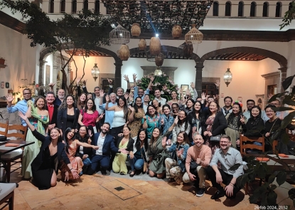 A large group of people posed for a photo in a hotel lobby