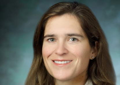 Dr. Caitlin Hicks smiles for a professional photo in her white coat.