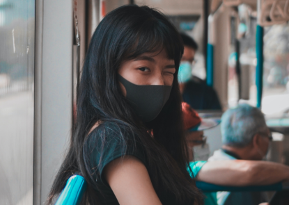 Young girl on a bus wearing mask during COVID-19 Pandemic