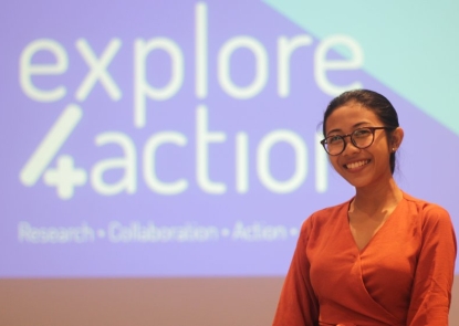 young adult woman standing in front of a large screen after finishing a presentation Explore 4 Action
