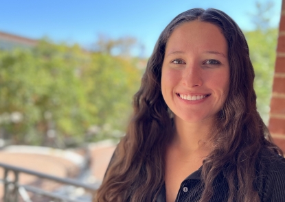 EHE-Taylor-Voelkel Head shot of young woman with long hair with campus in the background