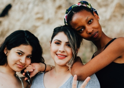 Three teenage girls with their arms around each other 