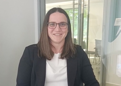 A woman in business casual attire sitting in a chair