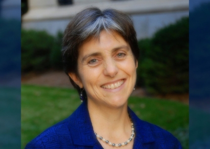 A headshot of a woman wearing a lavender collared shirt